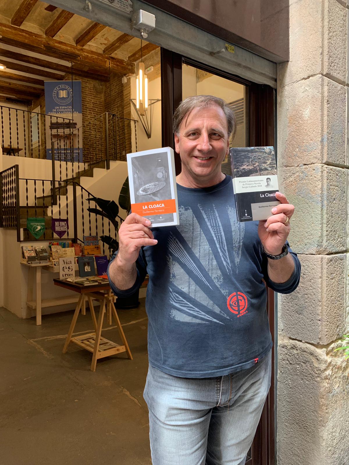 El autor Guillermo Ferreyro junto a la edición argentina y la edición mexicana de La Cloaca